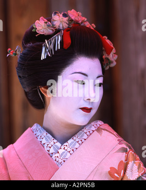 Fille de Geisha maiko stagiaire costume au jardin japonais de Kyoto Gion portant perruque obi kimono parasol makeup Banque D'Images