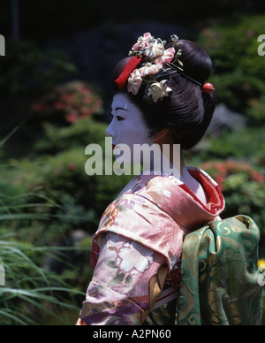 Fille de Geisha maiko stagiaire costume au jardin japonais de Kyoto Gion portant perruque obi kimono parasol makeup Banque D'Images