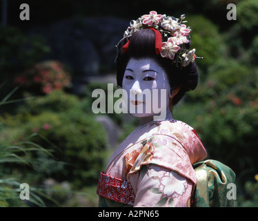 Fille de Geisha maiko stagiaire costume au jardin japonais de Kyoto Gion portant perruque obi kimono parasol makeup Banque D'Images