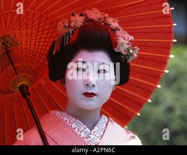 Fille de Geisha maiko stagiaire costume au jardin japonais de Kyoto Gion portant perruque obi kimono parasol makeup Banque D'Images