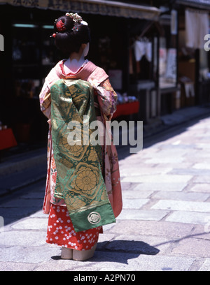 Fille de stagiaire costume Geisha maiko marche le long de la rue de Kyoto Gion portant perruque obi kimono parasol makeup Banque D'Images