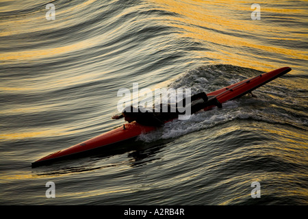 Les palettes à un conseil d'homme comme l'aube au-dessus de l'océan Pacifique comme vu à partir de la jetée de Santa Monica Santa Monica California USA Banque D'Images