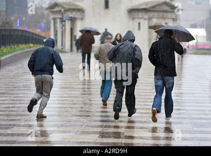 Les piétons qui traversent façon centenaire à Birmingham, Royaume-Uni, pendant une tempête de pluie Banque D'Images