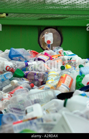 Une femme dépose une bouteille en plastique dans un bac de recyclage dans le Worcestershire UK Banque D'Images
