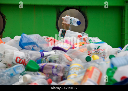 Une femme dépose une bouteille en plastique dans un bac de recyclage dans le Worcestershire UK Banque D'Images