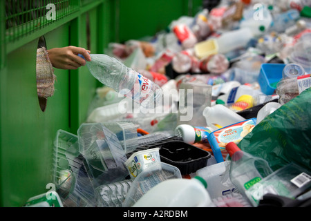 Une femme dépose une bouteille en plastique dans un bac de recyclage dans le Worcestershire UK Banque D'Images