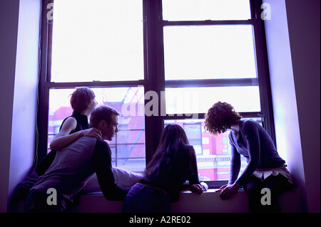 Les gens qui se profile at window Banque D'Images