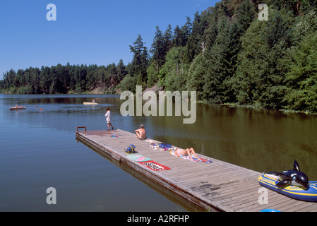 L'île Pender Nord, Sud des îles Gulf, en Colombie-Britannique, Colombie-Britannique, Canada - bronzer sur un quai sur le lac magique Banque D'Images