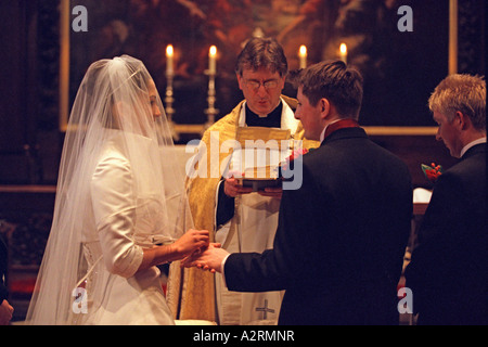 Mariée à l'autel avec son homme échangent les anneaux de mariage à St George's Church London Banque D'Images