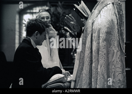 Mariée à l'autel avec son fiancé faire leurs vœux de mariage à St George's Church London Banque D'Images