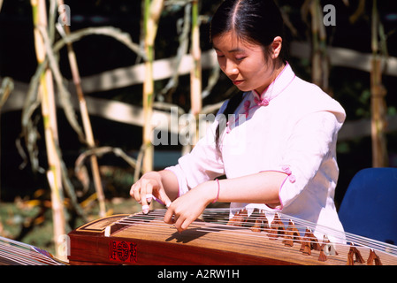 Femme orientale jouant cithare chinoise / harpe (aka Guzheng), Vancouver, BC, British Columbia, Canada Banque D'Images