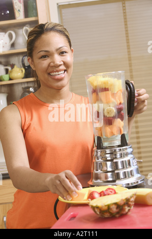 Femme faisant une boisson aux fruits mélangés Banque D'Images