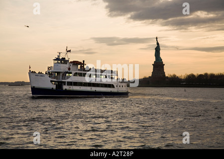 Circle Line ferry et la Statue de la Liberté au coucher du soleil. New York USA Banque D'Images