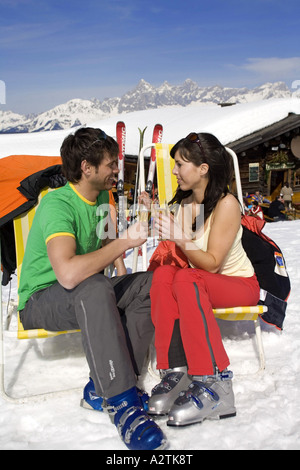 Dans l'amour couple drinking champagne près de chalet de montagne Banque D'Images