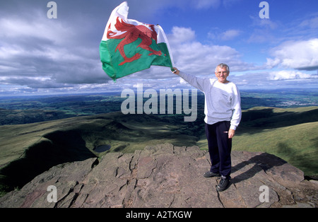 Avec l'homme drapeau gallois sur le sommet de Pen-y-Fan, parc national de Brecon Beacons, Powys, Wales Banque D'Images