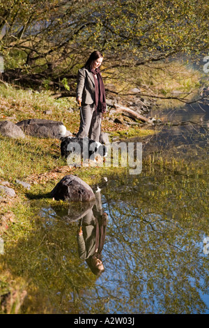 Woman walking dog en automne, réservoir de Talybont, Brecon Beacons NP, FR Banque D'Images