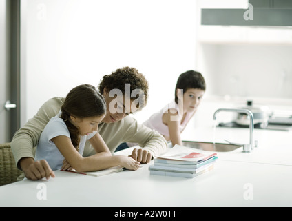 Aider un adolescent plus jeune soeur aux devoirs Banque D'Images