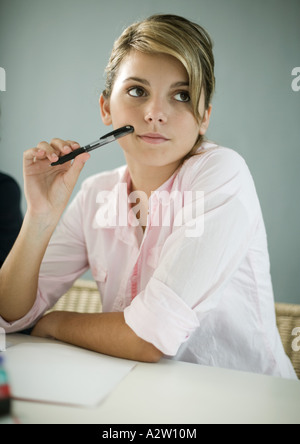 Teenage girl doing homework, assis, enclos à face Banque D'Images