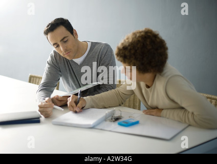 Aider père fils adolescent aux devoirs Banque D'Images