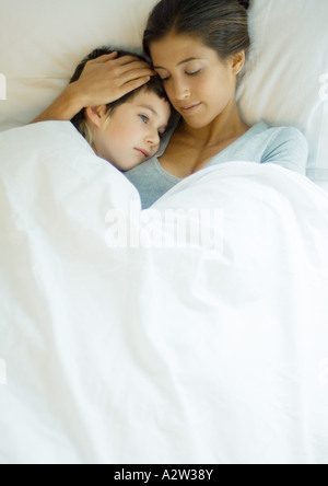 Femme et enfant couché sous couvre ensemble Banque D'Images