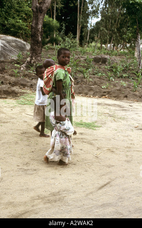 Jeune fille portant un bébé sur son dos à Nkhotakota, le lac Malawi, Malawi Banque D'Images