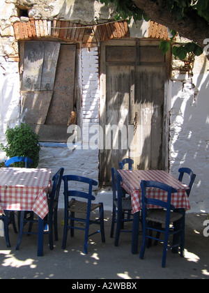 En dehors des tables de café restaurant grec avec ombre pommelé par arbre voisin Alonissos Grèce Banque D'Images