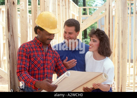 Couple heureux de parler avec house architect at construction site Banque D'Images