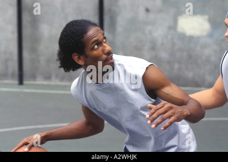Jeune homme jouant au basket-ball Banque D'Images