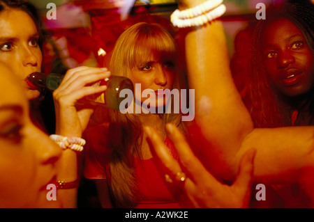 Groupe de femmes de boire une bière en discutant avec eux à une partie dans le centre de Londres, au Royaume-Uni. Banque D'Images