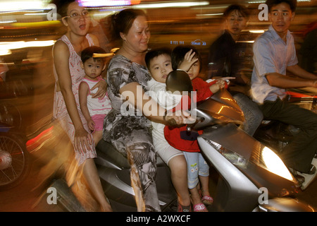 Une famille de cinq croisières en haut et en bas de la route Le Loi sur leur moto dans la nuit de samedi. Saigon, Vietnam Banque D'Images