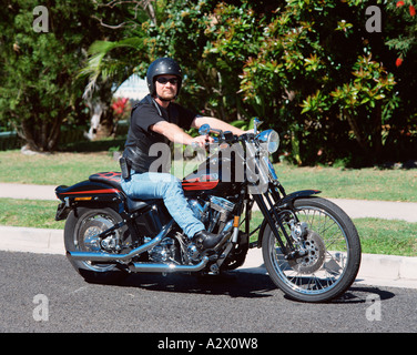 Man riding moto Harley Davidson sur rue de banlieue. Banque D'Images