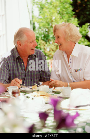 Senior couple having tea dehors à la maison sur la terrasse du jardin. Banque D'Images