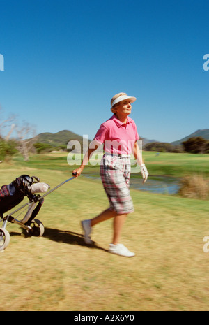 Femme plus âgée, la marche à l'extérieur sur le terrain de golf. Banque D'Images