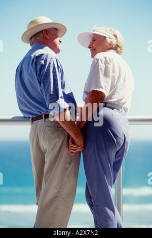 L'âge de la retraite couple debout sur une terrasse face à l'océan. Banque D'Images