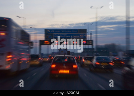 La conduite sur la A35 vers l'aéroport de Gatwick et M25. Le crépuscule. L'heure de pointe du soir. L'allumage des feux stop et des signes. UK. Banque D'Images