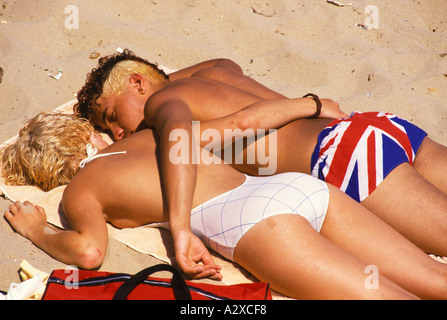 Vêtements Union Jack à la mode des années 1990. Jeune couple en vacances, bains de soleil sur la plage. Eastbourne Angleterre HOMER SYKES Banque D'Images