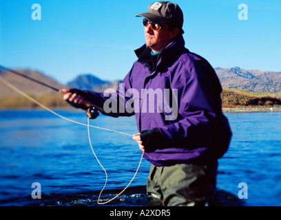 L'homme pêche en eau peu profonde au bord du lac. USA. Banque D'Images