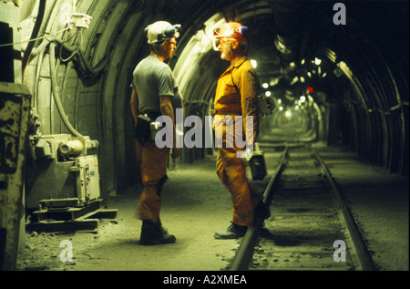 Mineurs avec des casques de sécurité et lampe frontale en pleine discussion dans tunnel souterrain AVEC LES VOIES FERRÉES. La mine de SHIREBROOK, Nottinghamshire. Banque D'Images