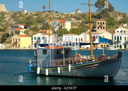 Bateau de pêche dans le port de Kastellorizo, Grèce. Le port est entouré de style néo-classique des maisons aux couleurs pastel Banque D'Images