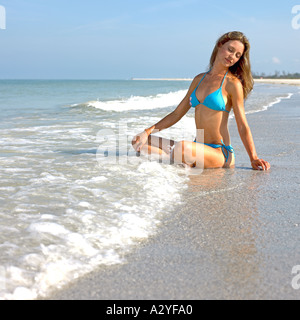 Les femmes de race blanche en bikini bleu se trouve dans surf Banque D'Images