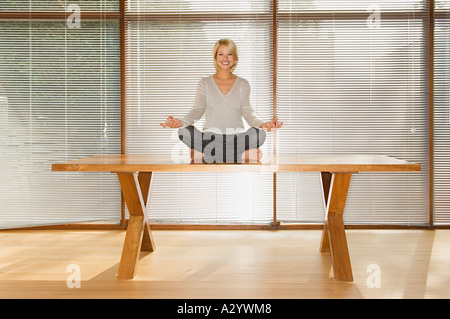 Woman sitting on table Banque D'Images