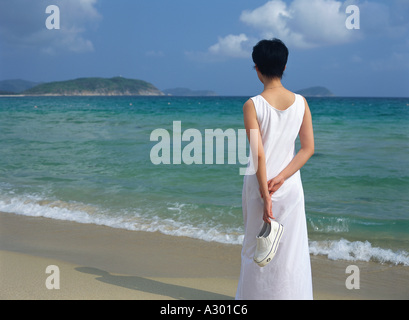 Jeune femme chinoise tenant une paire de chaussures de sport blanc Banque D'Images