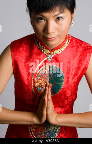 Close-up of Chinese woman salutation et portant un costume traditionnel Banque D'Images