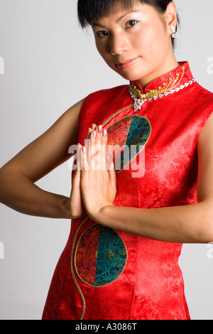 Close-up of Chinese woman salutation et portant un costume traditionnel Banque D'Images