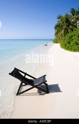 Chaises longues sur une plage des Maldives vide Banque D'Images