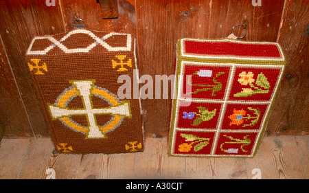 Poufs décoratifs tapisserie sur des crochets à l'arrière de l'église pew Banque D'Images