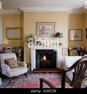 Style campagne anglaise salon avec cheminée pièce, fauteuil et tapis Banque D'Images