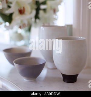 Close up de bols en porcelaine sur surface en marbre avec lis dans l'arrière-plan Banque D'Images