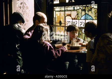 Famille avec enfants dans un pub en attente de leur lunch Dublin 2001 Banque D'Images