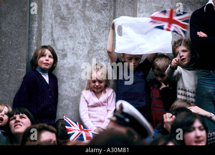 Enfants brandissant des drapeaux Union Jack et regardant le QE2 voile pour les îles Falkland 1982 Banque D'Images